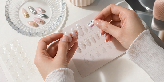 Hands comparing press-on nail sizes with sizing tools